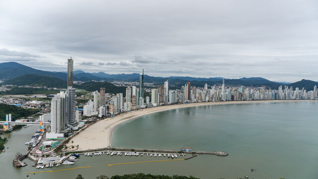 beachfront in Balne&aacute;rio Cambori&uacute;, Santa Catarina, Brazil, seen from above, beach and large building in the background.