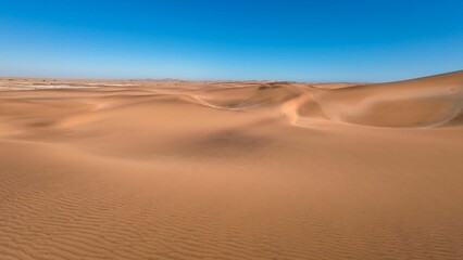 Serene desert landscape with sand dunes and clear blue sky in Namibia, Africa