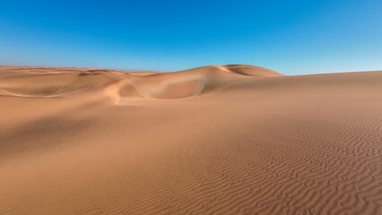 Serene desert landscape with sand dunes and clear blue sky in Namibia, Africa