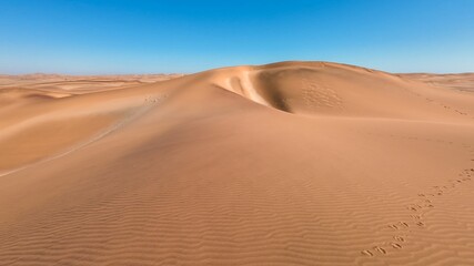 Serene desert landscape with sand dunes and clear blue sky in Namibia, Africa
