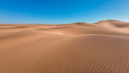 Serene desert landscape with sand dunes and clear blue sky in Namibia, Africa
