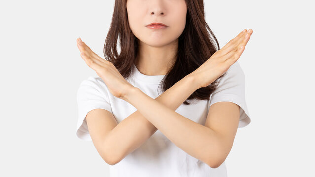 手でバツのポーズをする日本人女性