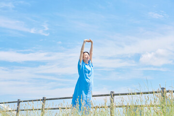 屋外で伸びをする女性