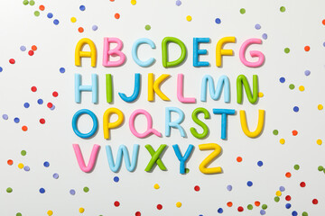 Alphabet made of colored plasticine on a light background.