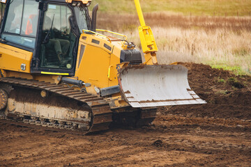 Yellow Bulldozer Clearing Land on  Construction Site During Day