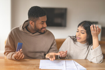 Couple Discussing Finances While Holding  Coin At Home