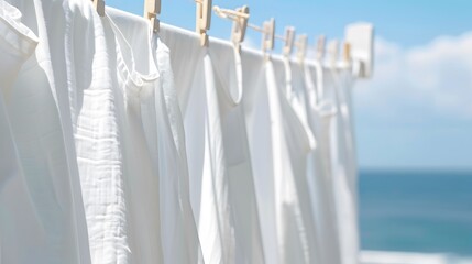 White Clothes Drying on a Clothesline with a Blue Sky and Ocean Background.