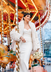 Bride Posing Near Carousel in Winter