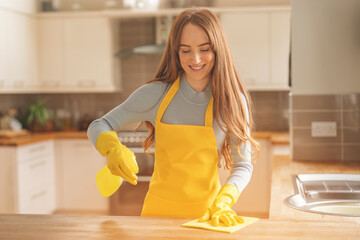 Woman Cleaning Kitchen Counter With Yellow Gloves and Cloth