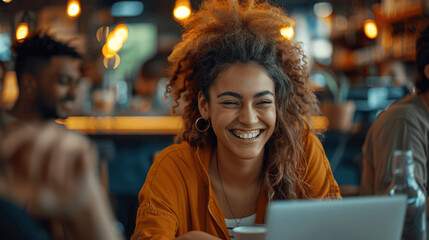 Obraz premium Young Diverse Group of Professionals Collaborating in a Cafe, Smiling and Enjoying a Casual Team Meeting with Laptops and Cinematic Lighting