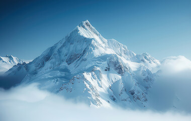 A beautiful snow capped mountain with clouds in the foreground and a blue sky in the background.