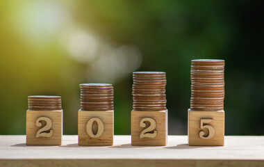 stack of coins on top 2025 number on wood block.