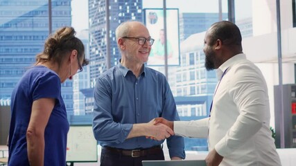 Senior citizens greeting banker to explore various retirement planning options, ensuring they make informed decisions about future financial stability. Consulting a financial advisor. Camera A.