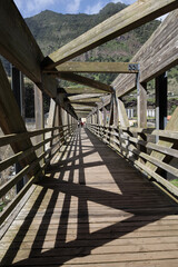 Wooden bridge with shadow over the river