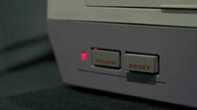 Close up of reset switch pressed in on video game system 4k
