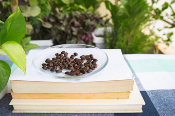Books and Coffee High Quality Dark Roasted Coffee Beans in Table with Plants Leaf