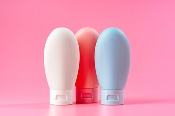 Three Plastic Squeeze Bottles on Pink Background