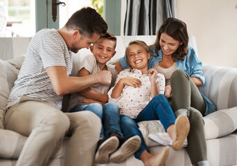Parents, children and laugh with tickle on couch with care, bonding or happy for connection in...