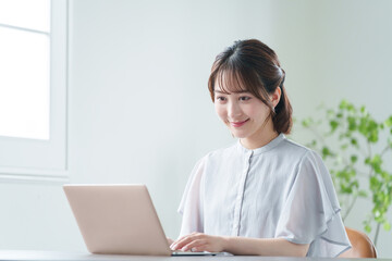 オフィスでパソコンを使って働くビジネスマン（女性・カジュアルビジネス）