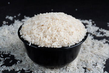 a bowl of rice on top of scattered rice on table