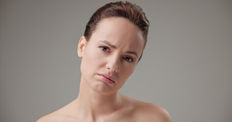 Fototapeta premium Beauty, health, cosmetics, anti-aging therapy and skin care concept - young beautiful brunette Caucasian woman in a bad mood, upset and disappointed experiencing negative emotions