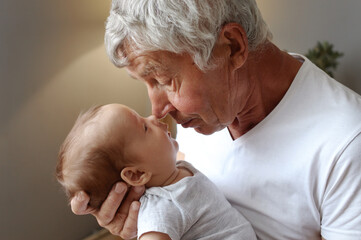 Loving grandfather with infant. Gentle grandparent with baby. Caucasian grandfather holding newborn...