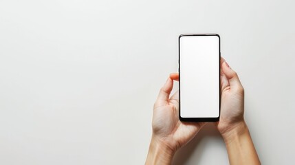 Womans hand holding a phone on a white background with space for copy Woman holding a smartphone with a blank screen closeup