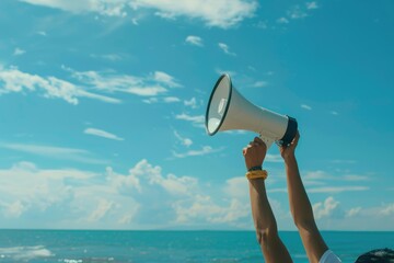 hand hold megaphone with sea under sky background
