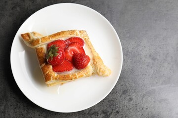 Tasty puff pastry with strawberries on grey table, top view. Space for text