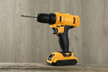 One cordless electric drill on wooden table