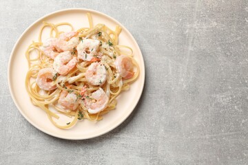 Delicious pasta with shrimps on grey table, top view. Space for text