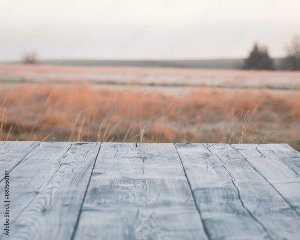 Poster tranquil rustic pastel grey wooden table with serene rural field and soft sunlight bokeh background