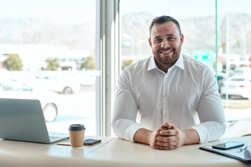 Man, smile and portrait in office at car dealership for promotion, sales or discount for vehicle. Person, auto salesman and business owner with pride, career or happy for entrepreneurship at showroom