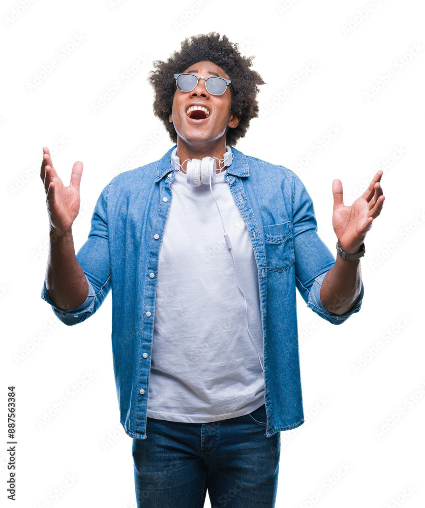 Poster afro american man wearing headphones listening to music over isolated background crazy and mad shout