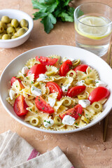 Farfalle pasta with white cheese, tomatoes and olives. Healthy eating. Vegetarian food.