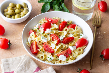 Farfalle pasta with white cheese, tomatoes and olives. Healthy eating. Vegetarian food.