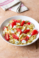 Farfalle pasta with white cheese, tomatoes and olives. Healthy eating. Vegetarian food.