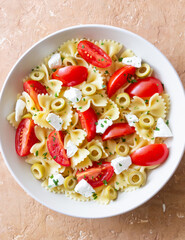 Farfalle pasta with white cheese, tomatoes and olives. Healthy eating. Vegetarian food.