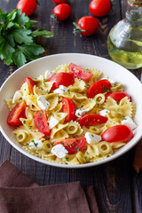 Farfalle pasta with white cheese, tomatoes and olives. Healthy eating. Vegetarian food.