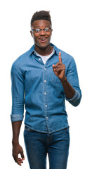 Young african american man over isolated background pointing finger up with successful idea. Exited...