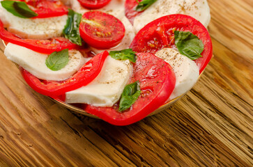 Delicious salad of cherry tomatoes, mozzarella cheese and basil. Close-up.