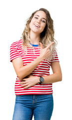 Fototapeta premium Beautiful young blonde woman over isolated background cheerful with a smile of face pointing with hand and finger up to the side with happy and natural expression on face