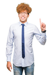 Young handsome business man with afro wearing glasses showing and pointing up with finger number one while smiling confident and happy.