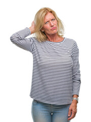 Fototapeta premium Middle age blonde woman over isolated background confuse and wonder about question. Uncertain with doubt, thinking with hand on head. Pensive concept.