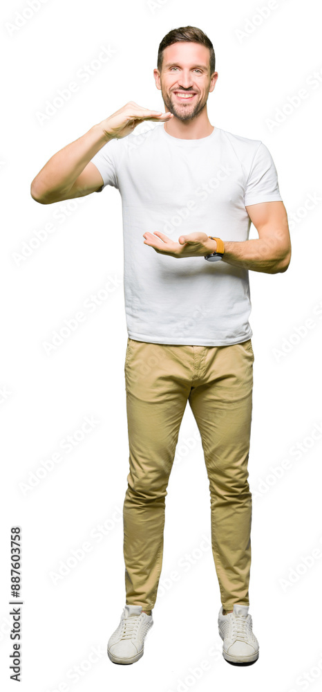 Canvas Prints Handsome man wearing casual white t-shirt gesturing with hands showing big and large size sign, measure symbol. Smiling looking at the camera. Measuring concept.