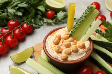 Tasty homemade hummus with chickpeas served on light grey table, closeup