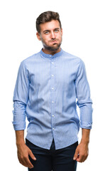 Fototapeta premium Young handsome man over isolated background puffing cheeks with funny face. Mouth inflated with air, crazy expression.