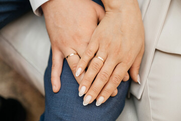 The hands of the bride and groom with wedding rings.