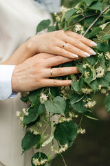 The hands of the bride and groom with wedding rings.