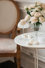 flowers in a glass. Three times in a glass. Light soft colors. Aesthetics. Marshmallows on the table.